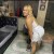Encantadora mujer latina sonriendo con vestido blanco